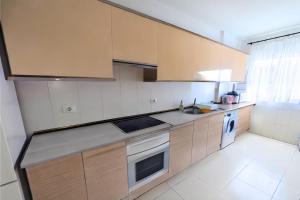 a kitchen with wooden cabinets and a sink and a stove at HAPPY & SUNNY Tenerife South in San Isidro +14 photos