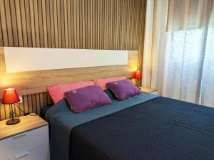 a bedroom with a blue bed with two purple pillows at HAPPY & SUNNY Tenerife South in San Isidro