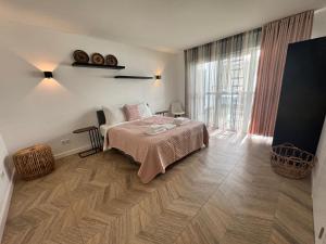 a bedroom with a bed and a large window at Homes by the C in Zandvoort
