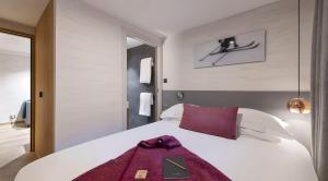 ヴァル・ディゼールにあるLuxueux duplex accès direct aux pistes avec piscine privéeのベッドルーム(紫色の毛布が敷かれた白い大型ベッド1台付)