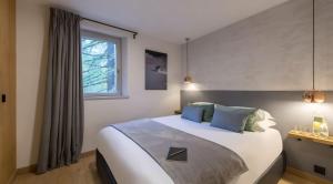 ヴァル・ディゼールにあるLuxueux duplex accès direct aux pistes avec piscine privéeの大きな白いベッドと青い枕のある寝室 +22枚の写真