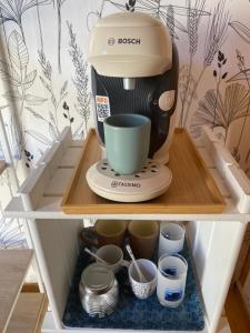 a coffee maker sitting on a shelf with cups at Villa Caplanne in Sanguinet