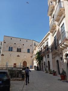 a man walking down a street next to buildings at New Design Ortigia in Siracusa