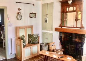 Zimmer mit einem Tisch und einer Uhr an der Wand in der Unterkunft 18th Century Cosy Cottage with Stunning views in Stratford in Stratford-upon-Avon