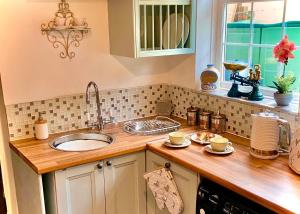 eine Küche mit Spüle und Arbeitsplatte in der Unterkunft 18th Century Cosy Cottage with Stunning views in Stratford in Stratford-upon-Avon + 13 Fotos