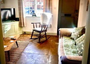ein Wohnzimmer mit Sessel und Couch in der Unterkunft 18th Century Cosy Cottage with Stunning views in Stratford in Stratford-upon-Avon