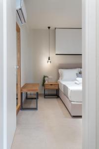 a bedroom with a bed and a table at GeoMar Luxury Apartments in Skala Marion