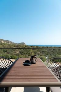 a wooden table with two chairs on a balcony at GeoMar Luxury Apartments in Skala Marion