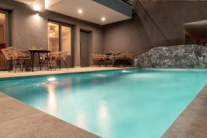 a swimming pool in a hotel with a table and chairs at GeoMar Luxury Apartments in Skala Marion