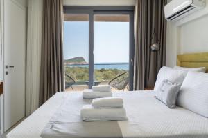 a hotel room with a bed with towels on it at GeoMar Luxury Apartments in Skala Marion