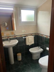 a bathroom with a sink and a toilet and a mirror at Apartamento en Infiesto Centro in Infiesto +10 photos