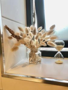 a glass vase filled with dried plants next to a window at Rum med sjöutsikt in Ockelbo +7 photos