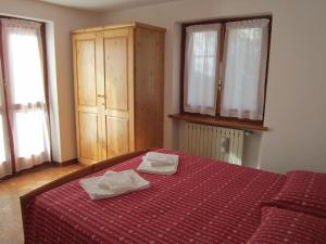 een slaapkamer met een bed met twee handdoeken erop bij Apartment Tea in Gressoney-Saint-Jean