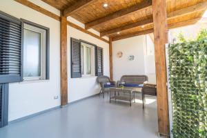 a patio with a table and chairs and windows at A casa di zia Maria in Olmedo