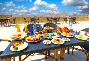 a table with plates of food on a patio at Venus Pyramids-Guest House in Cairo