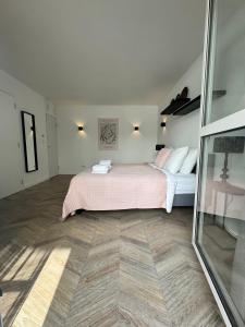 a bedroom with a bed with pink sheets and a mirror at Homes by the C in Zandvoort