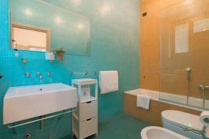 a bathroom with a sink and a toilet and a mirror at Villa Locana con Jacuzzi e vista lago in Laglio +23 photos