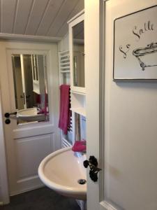 a white bathroom with a sink and a mirror at gemütliches Blockhaus - das Hundeparadies am Wald in Wiehl