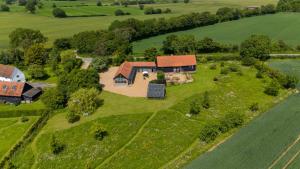 an aerial view of a house on a green field at The Suites at Pannells Ash in Castle Hedingham