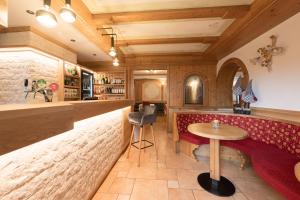 a bar with a red bench and a table at Hotel Zirmes in Moena