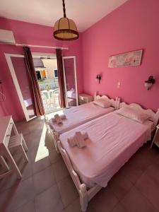 1 dormitorio con 1 cama grande y paredes de color rosa en Telis apartments, en Rodas 5 fotos más