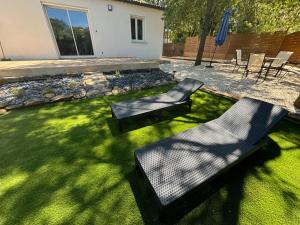 a backyard with two chairs and a lawn at Maison au calme, piscine, terrain de pétanque in Deaux