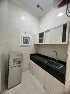 a small kitchen with a sink and a refrigerator at بناية حمران-RED-9-Hamren in Ma‘mūrah +20 photos