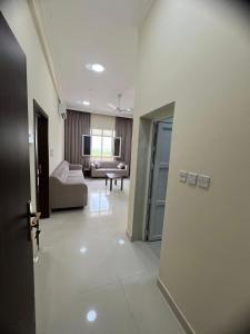 an open door to a living room with a couch at بناية حمران-RED-9-Hamren in Ma‘mūrah