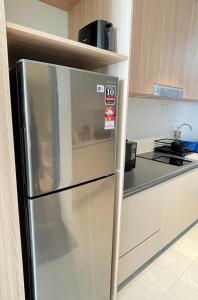 een roestvrijstalen koelkast in een keuken bij Freedom Flamingos-RoxyBeachApt in Sematan +39 foto's