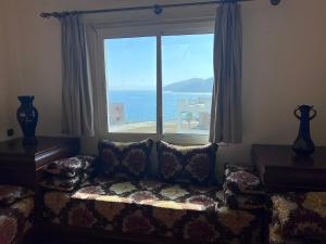 a living room with a couch and a large window at Complexe tarifa in Tangier