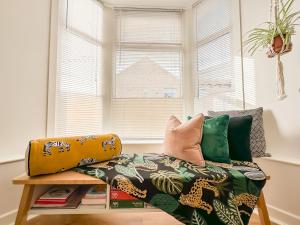 a couch with pillows on it in front of a window at Chic Beamish Retreat Stylish 3-Bed Near Durham - Pass the Keys in Stanley