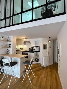 a kitchen with a counter and chairs in a room at Appartement idéalement situé in Les Sables-dʼOlonne