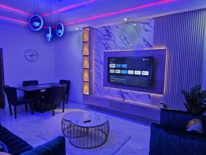 a dining room with a table and a tv on a wall at Skyline Apartments in Lagos
