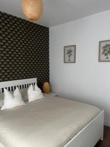Un dormitorio con una cama blanca con almohadas blancas. en Appartement Dalayrac, en Fontenay-sous-Bois