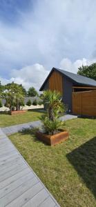 a house with two plants in front of it at Grey Sea Rusinowo in Rusinowo