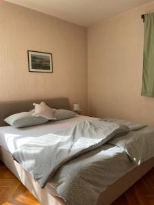 a bed in a bedroom with a picture on the wall at Green House Livno in Livno +2 photos