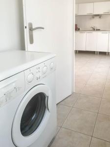 a white washer and dryer in a white kitchen at Kusmi Love piscine proche du lac in Annecy