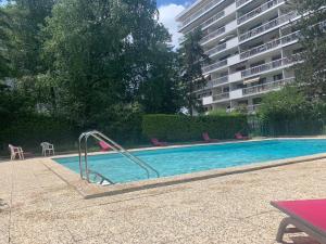 a swimming pool with a slide in front of a building at Kusmi Love piscine proche du lac in Annecy