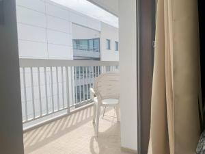 a white chair sitting on a balcony with a window at Kusmi Love piscine proche du lac in Annecy