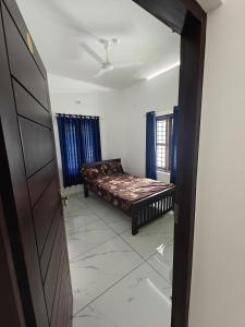 a bedroom with a bed in the middle of a room at Aadhi Villa in Varkala +17 photos