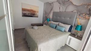 a bedroom with a large bed with a headboard at Bungalow Uno - Front Line of Ocean in San Bartolomé de Tirajana +41 photos