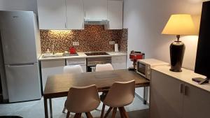 a kitchen with a table and chairs in a kitchen at Bungalow Uno - Front Line of Ocean in San Bartolomé de Tirajana