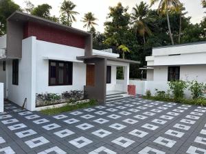 a house with a brick courtyard in front of it at Aadhi Villa in Varkala