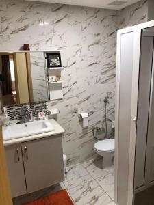 a white bathroom with a sink and a toilet at Sable d'or in Saidia 