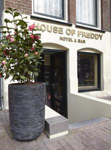 a large vase with a plant in front of a store at House of Freddy in Amsterdam