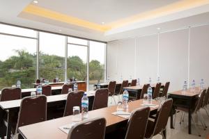 einen Konferenzraum mit Tischen, Stühlen und Fenstern in der Unterkunft Amaris Hotel Citra Raya – Tangerang in Tangerang