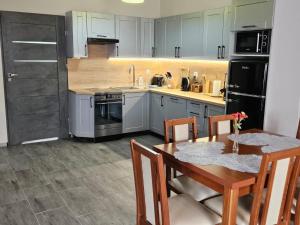 a kitchen with a wooden table and a kitchen with white cabinets at Noclegi -Chata Polska in Chrostkowo