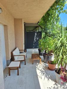 イモツキにあるLUXURY Apartment IMOTA,with private pool,big Free Parking,Car EVchargerの椅子とテーブルと植物のあるパティオ