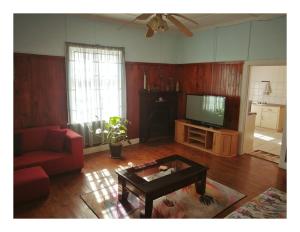 Una sala de estar con un sofá y un televisor. en Swartkops Cann-a-bee Air B&B, en Gqeberha