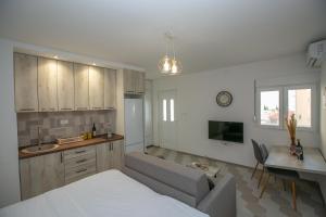 a kitchen and living room with a bed and a table at Vila Varagic in Budva